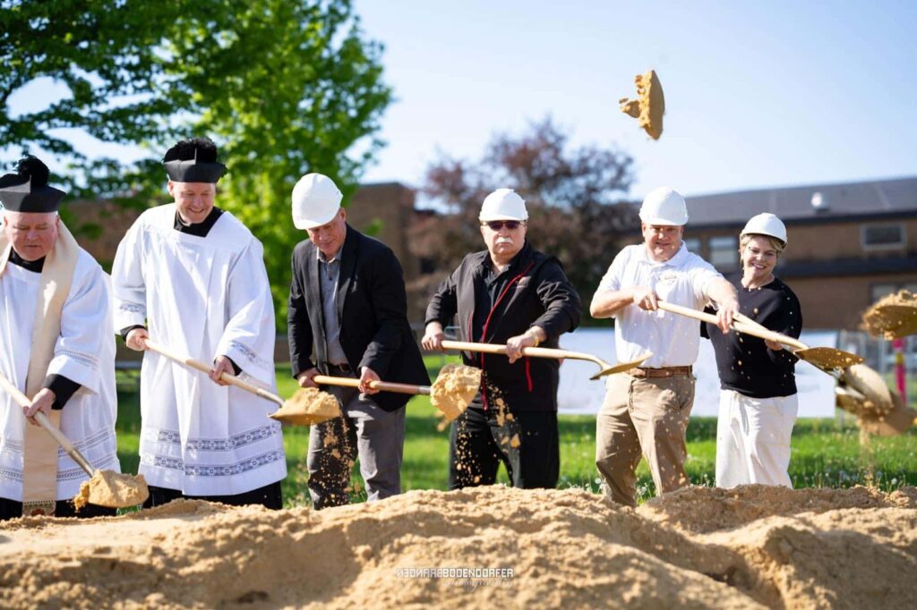Groundbreaking ceremony with ceremonial shovels at the Columbus Catholic building site